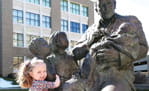 Young patient with Sabin statue at Cincinnati Children's. 